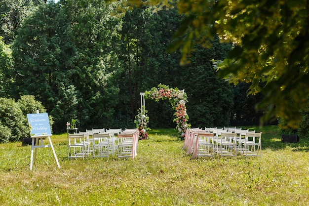 Photo wedding ceremony decorations chairs mirror pointer and a lot of flowers in white and pink colors