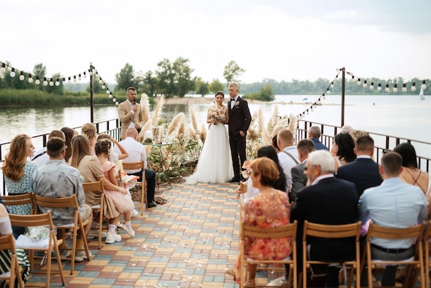 Wedding ceremony on a high pier near the river