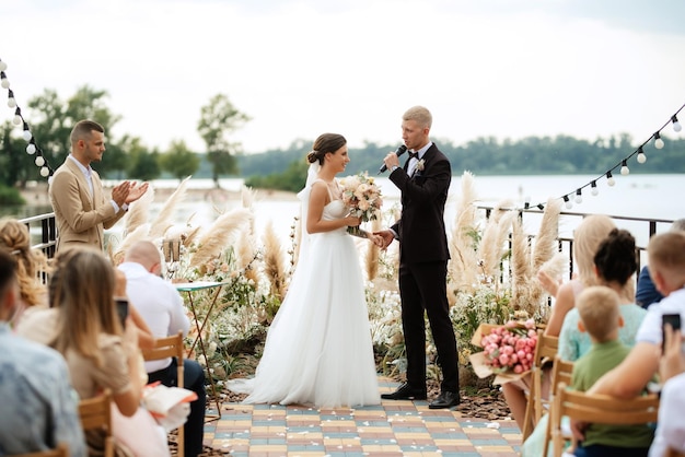 Wedding ceremony on a high pier near the river