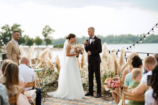 Wedding ceremony on a high pier near the river