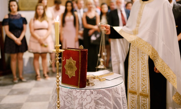 Фото Венчание в православном храме священник в белом рясе стоит в храме на
