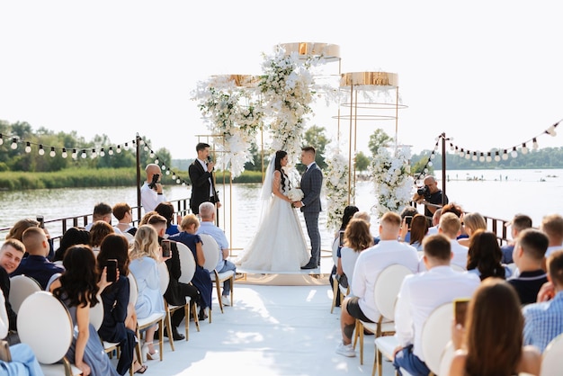 Photo wedding ceremony of the newlyweds on the pier