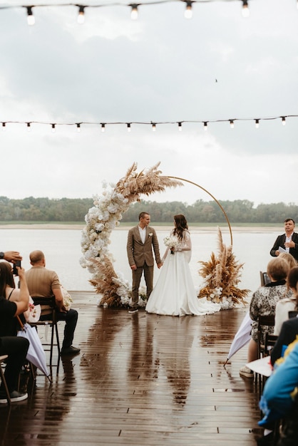 Photo wedding ceremony of the newlyweds on the pier