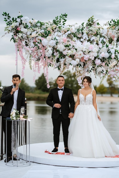 Photo wedding ceremony of the newlyweds on the pier