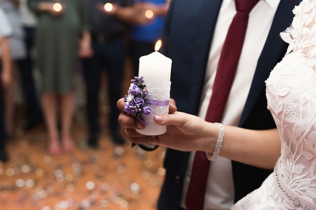 Wedding ceremony, paraphernalia, the bride and groom hold a large candle in their hand