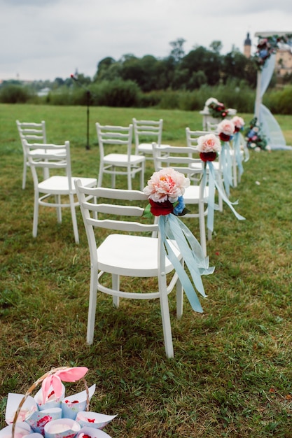 Matrimonio in strada sul prato verde. decorazioni con archi di fiori freschi per la cerimonia.