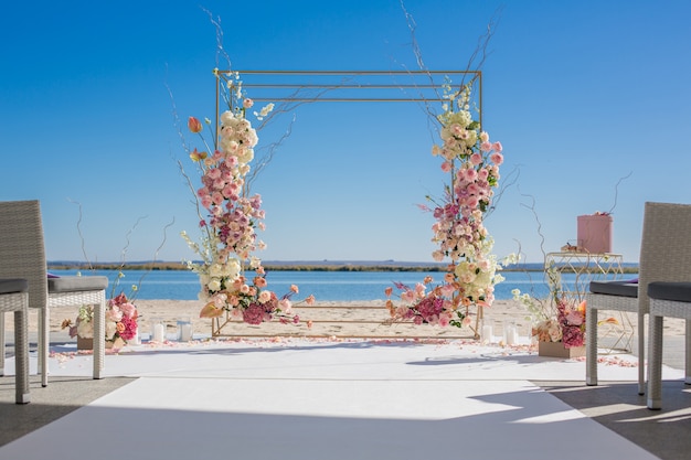 Wedding chuppa at riverside decorated with fresh flowers. 