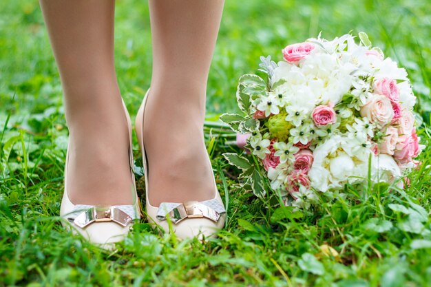 Photo wedding concept. bouquet and shoes  on grass