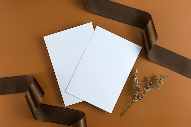 A wedding concept. Wedding Invitation on brown background with ribbon.