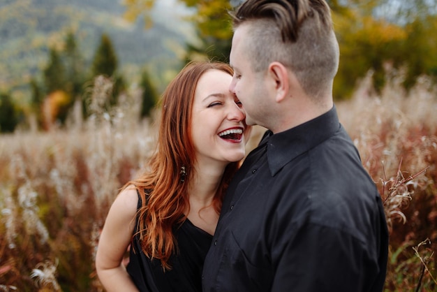 秋の山々を背景に結婚式のカップル