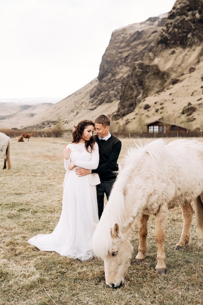 結婚式のカップルとクリーム色の馬