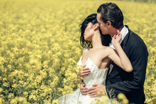 Wedding couple in field yellow flowers