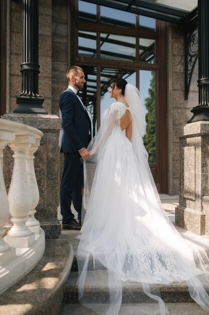 Wedding couple of groom and bride stand on balcony Beautiful couple