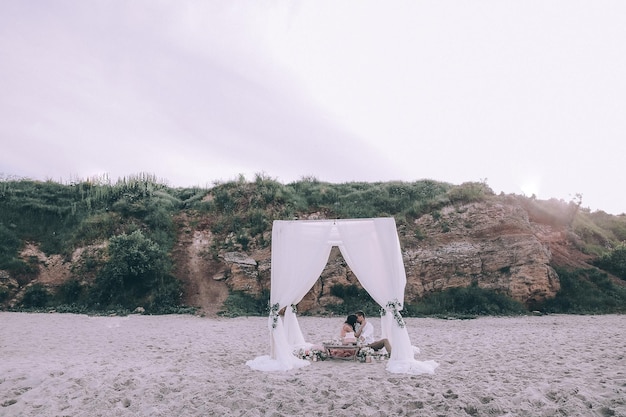 写真 結婚式のカップル、新郎、海と青空に近いポーズのブーケを持つ花嫁