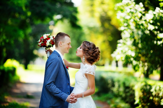 Wedding couple, happy newlyweds and husband hugging in green park.