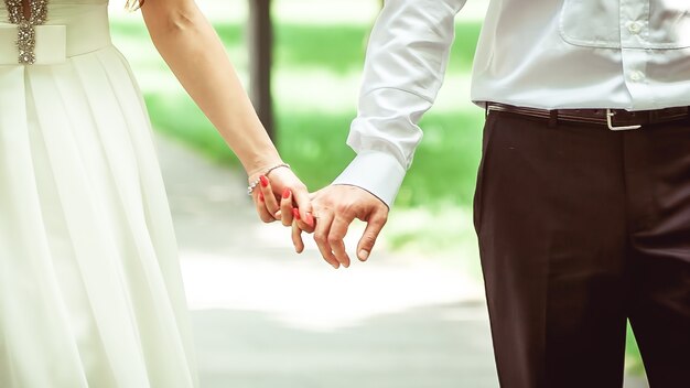 手をつないで結婚式のカップル。新郎新婦