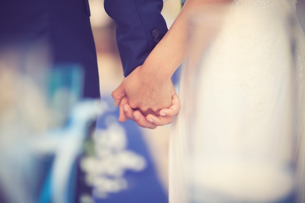 日没の背景に手を握っている結婚夫