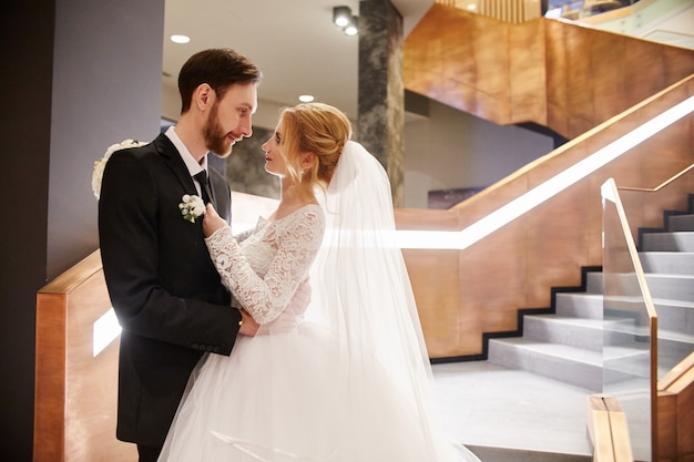 Wedding couple hugging and kissing, first day life together. Bride and groom after wedding ceremony, beautiful couple love