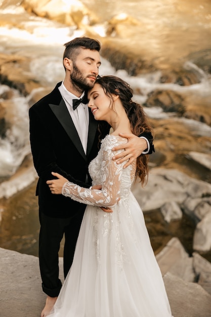 Свадебная пара, влюбленные на фоне каменной реки.