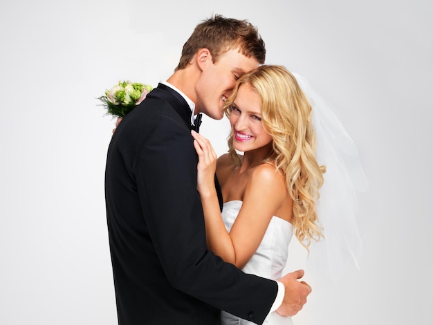 웨딩 커플 및 흰색 배경에 스튜디오에서 한 쌍으로 신부 및 신랑과의 결혼 축하 행사 또는 행사에서 결혼하는 남자와 여자와 정장과 꽃