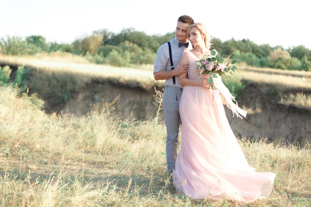 Wedding couple on the nature in summer day. the bride and groom hugging at the wedding.