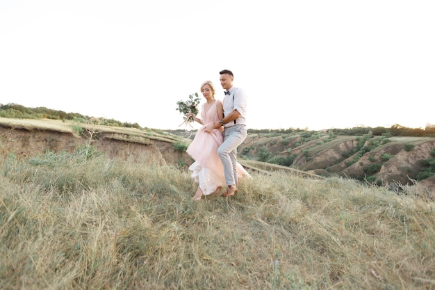 Wedding couple on the nature in summer day. the bride and groom walking