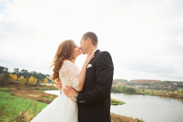 Wedding couple on panorama of city and river. bride with long veil