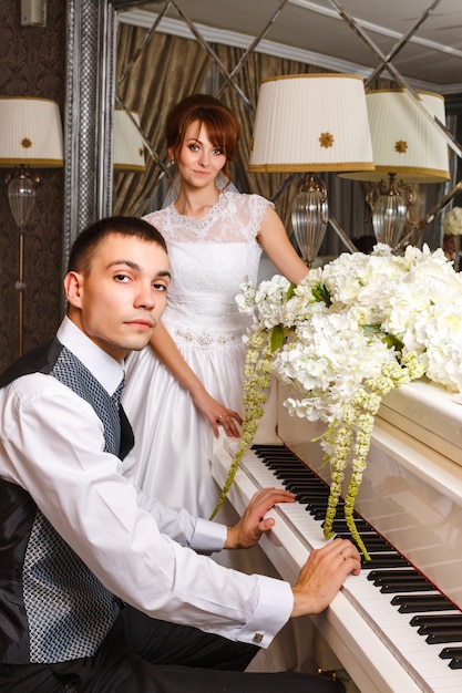 Wedding couple playing on a piano