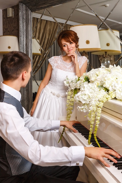 Wedding couple playing on a piano