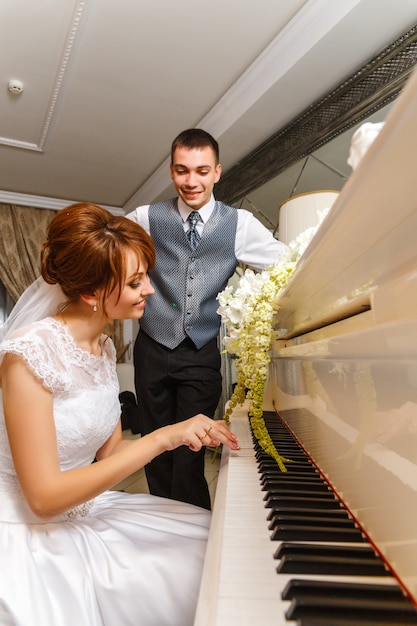 Wedding couple playing on a piano