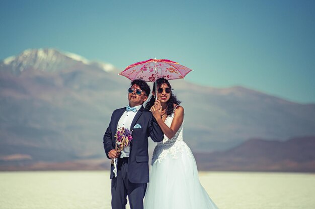 Wedding couple posing in a white landscape with accessories