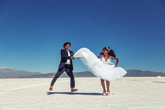 Wedding couple posing in a white landscape with accessories