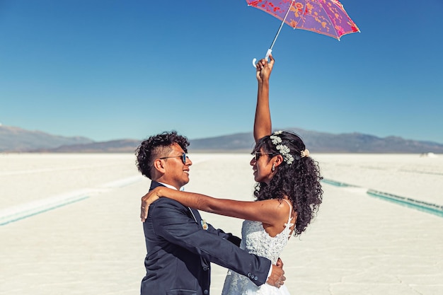 Wedding couple posing in a white landscape with accessories