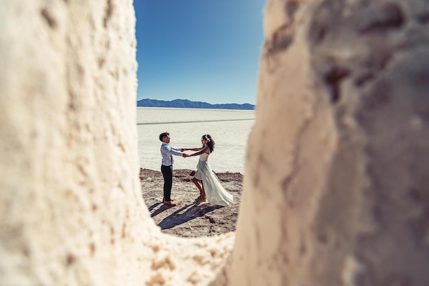 Wedding couple posing in a white landscape with accessories