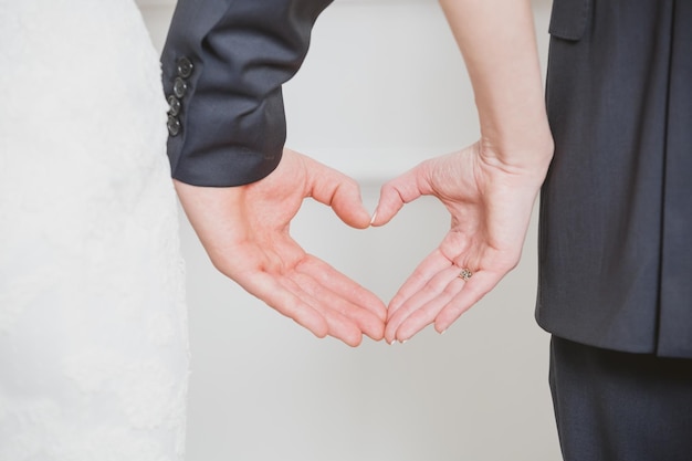 写真 手からハートの形を示す結婚式のカップル