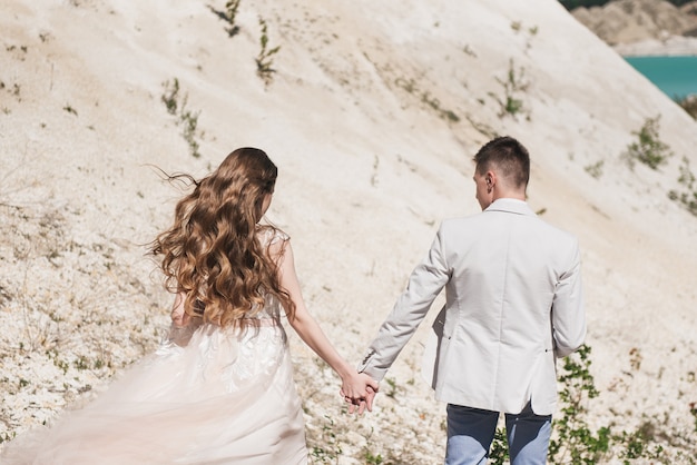 Wedding couple standing on a sandy hill