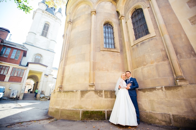 街の通りを歩いて結婚式のカップル