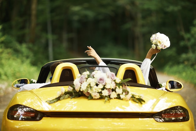 Photo wedding couple with a wedding car