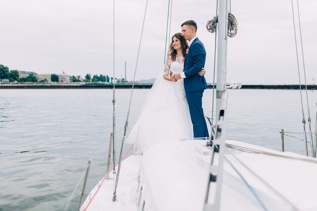 Wedding couple on the yacht, lovers posing on the yacht