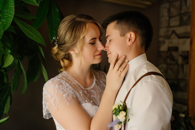 Photo wedding day. newlyweds in show feelings for each other hug and touch their noses.