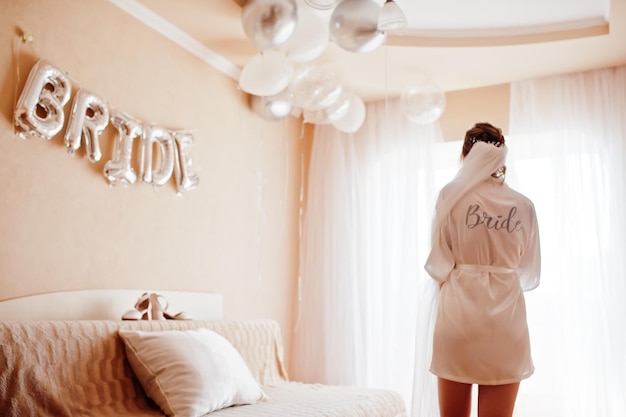 Wedding day preparation Bride wearing a white bridal bathrobe