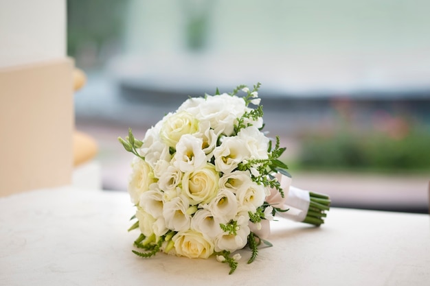 テーブルの上の白い花の丸いボールの花嫁の花束と結婚式の装飾