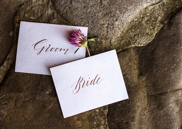 Wedding details flat lay on stone background wedding invitation\
ring box mock up copyspace clover