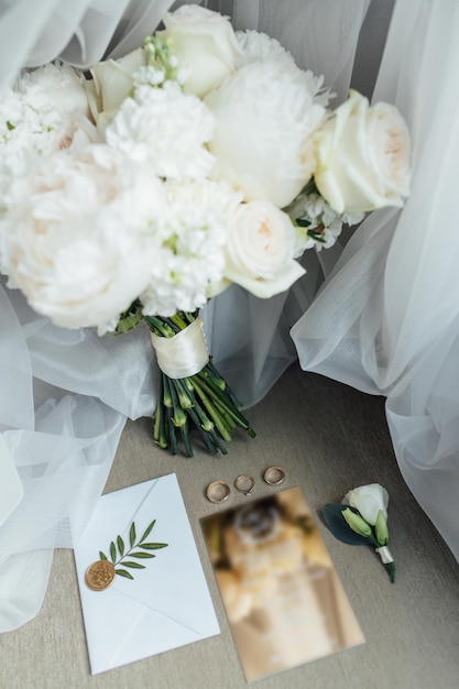 Wedding details flat lay. Wedding invitation and scroll paper. Bottle with fragrance. Simple bouquet