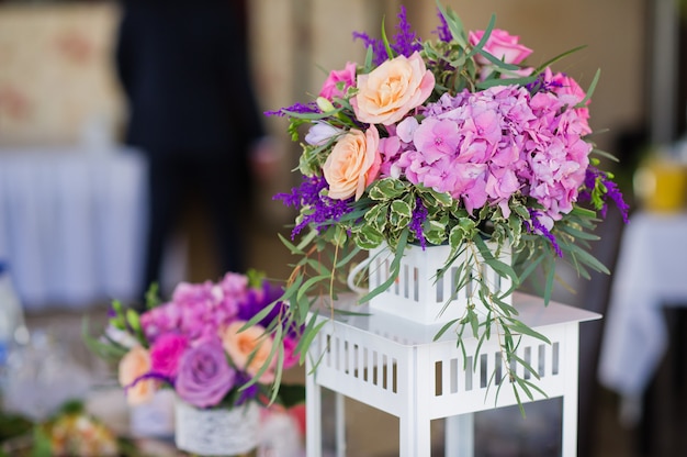 Wedding dinner in the restaurant, tables decorated with vases of roses.