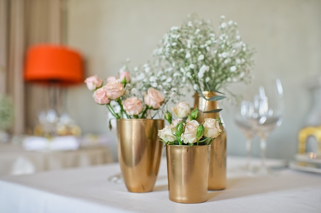 Wedding dinner in the restaurant, tables decorated with vases of roses.