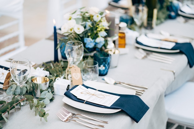 Wedding dinner table reception a square plate with a blue cloth towel knives and forks next to the