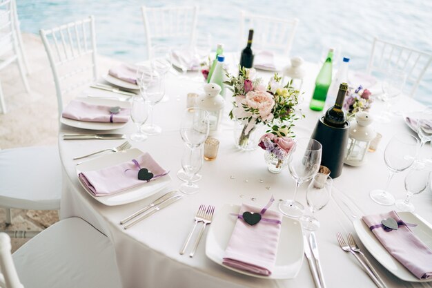 Wedding dinner table reception white square plates on a round table with pink rag napkins with a