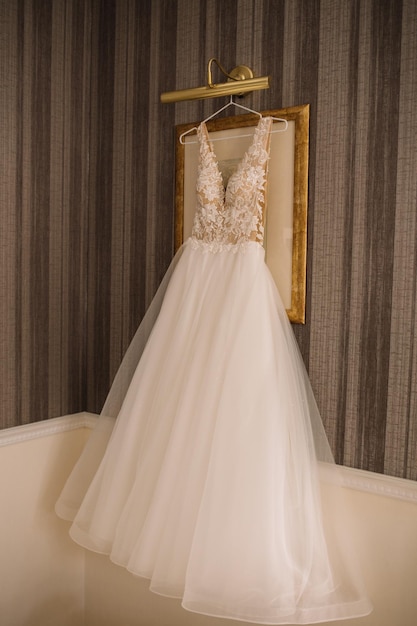 Wedding dress hanging against a wall background in the room Close up