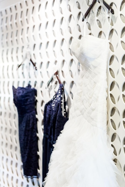 Wedding dress hanging on a white wall with pattern.